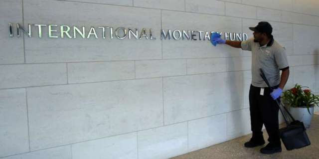 Staff cleans signage at International Monetary Fund headquarters