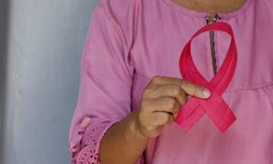 Una mujer sujeta un lazo rosa en conmemoración del Día contra el Cáncer de Mama.
