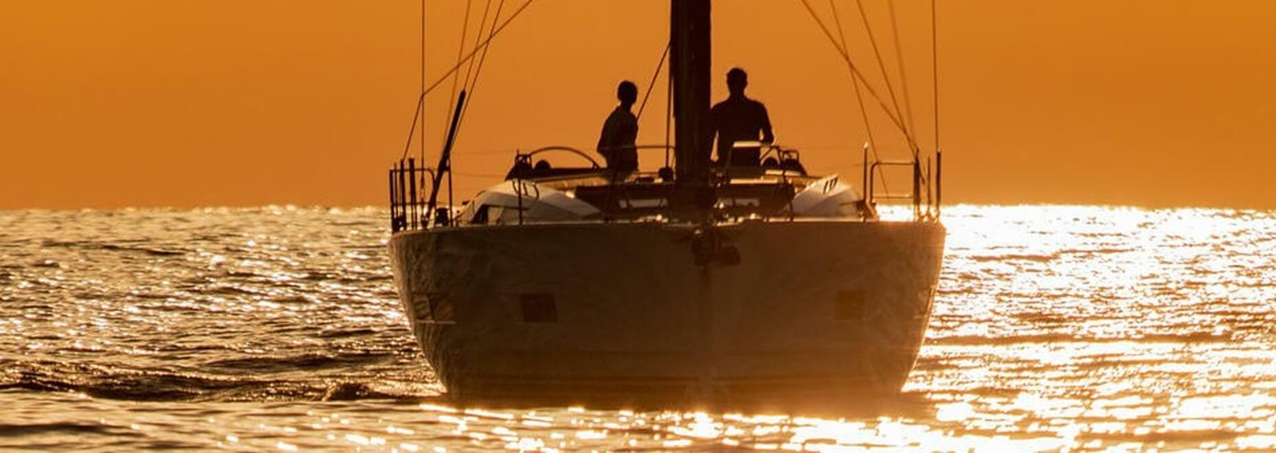 Hanse 460 sailing yacht on the water with a orange horizon
