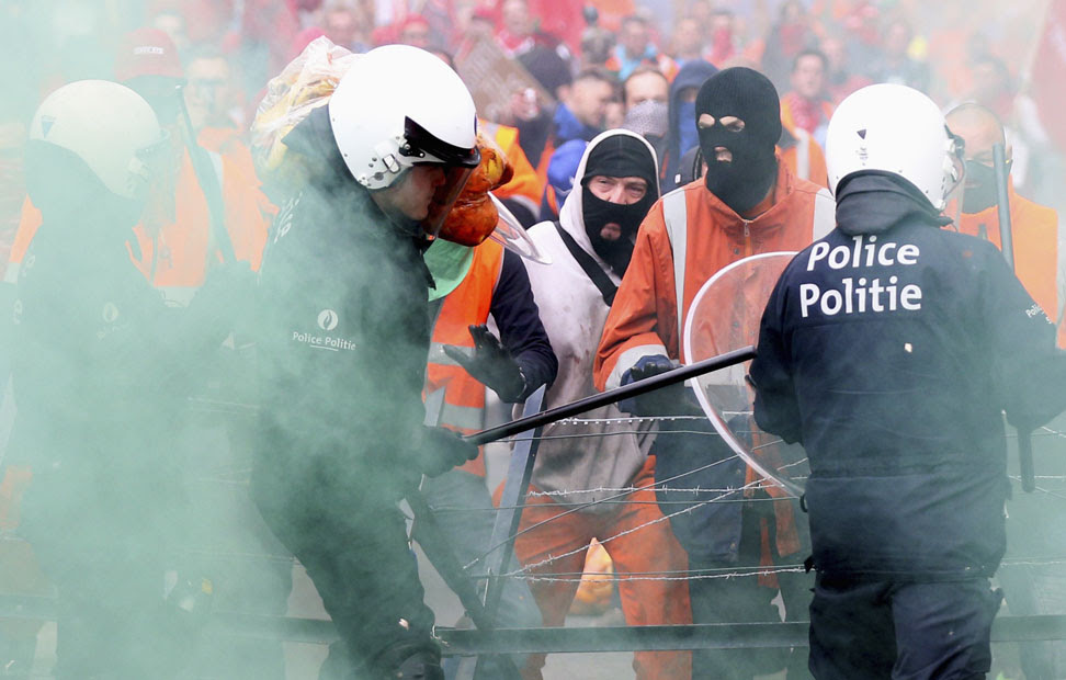 Un grupo de manifestantes se enfrenta a los policías antidisturbios durante la protesta sindical europea contra las medidas de austeridad, en el centro de Bruselas.