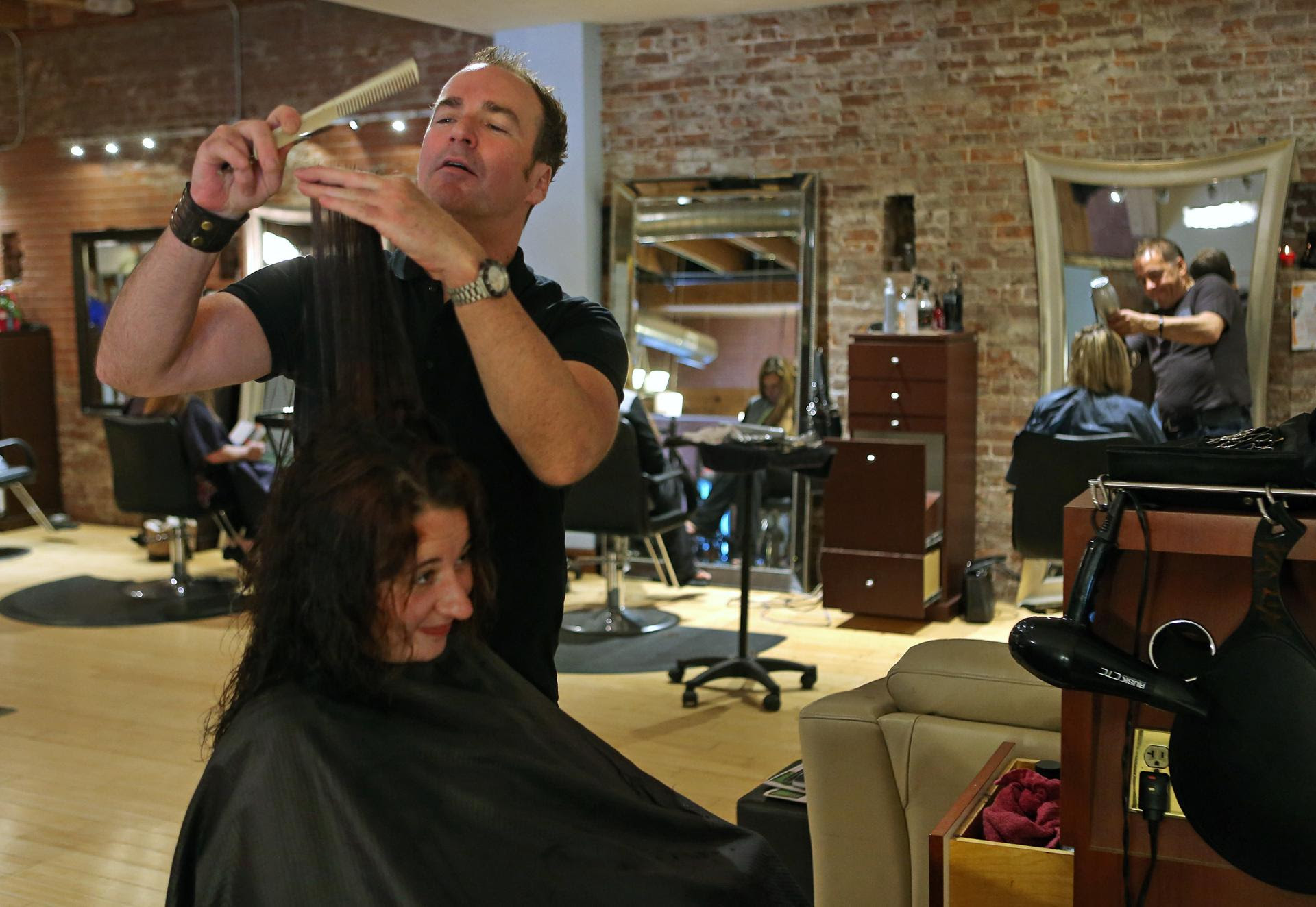  David McCarthy, a STOP program graduate, cut a customer’s hair in a Worcester salon.