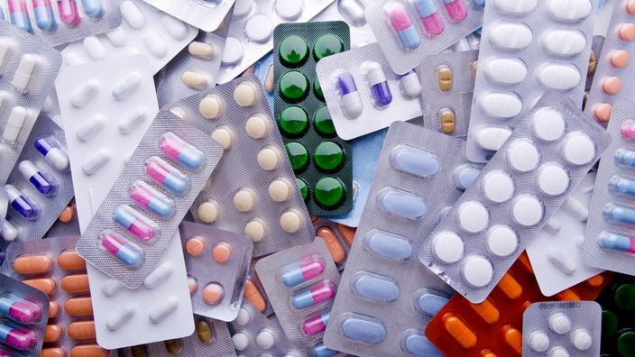 A colorful assortment of tablets and capsules in blister packs.