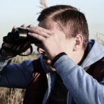 Young Male Spying Binocular Looking Forward Person