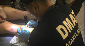 DMAT clinician suturing a leg