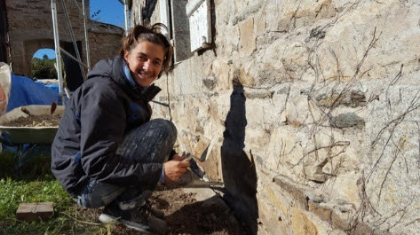 Hugo Salvador, fundador de Workforme, reparando un muro de piedra con materiales sostenibles.