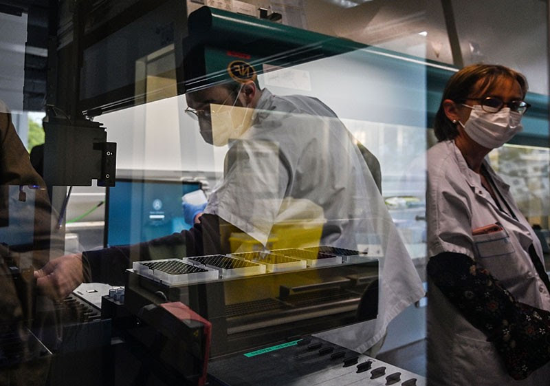 Medical staff prepare nasal swabs for analysis in a high detection rate PCR machine at the Croix-Rousse hospital in Lyon, France