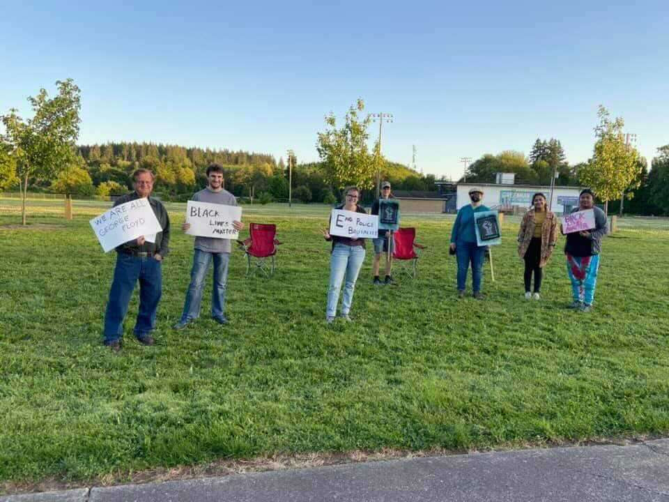 demonstrators holding BLM and other signs