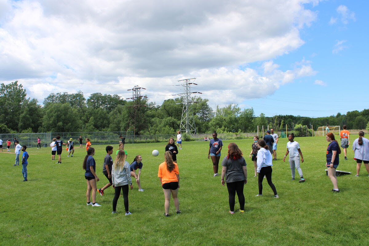 students play field day games outdoors on grass