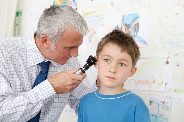 Doctor examining a boy's ear