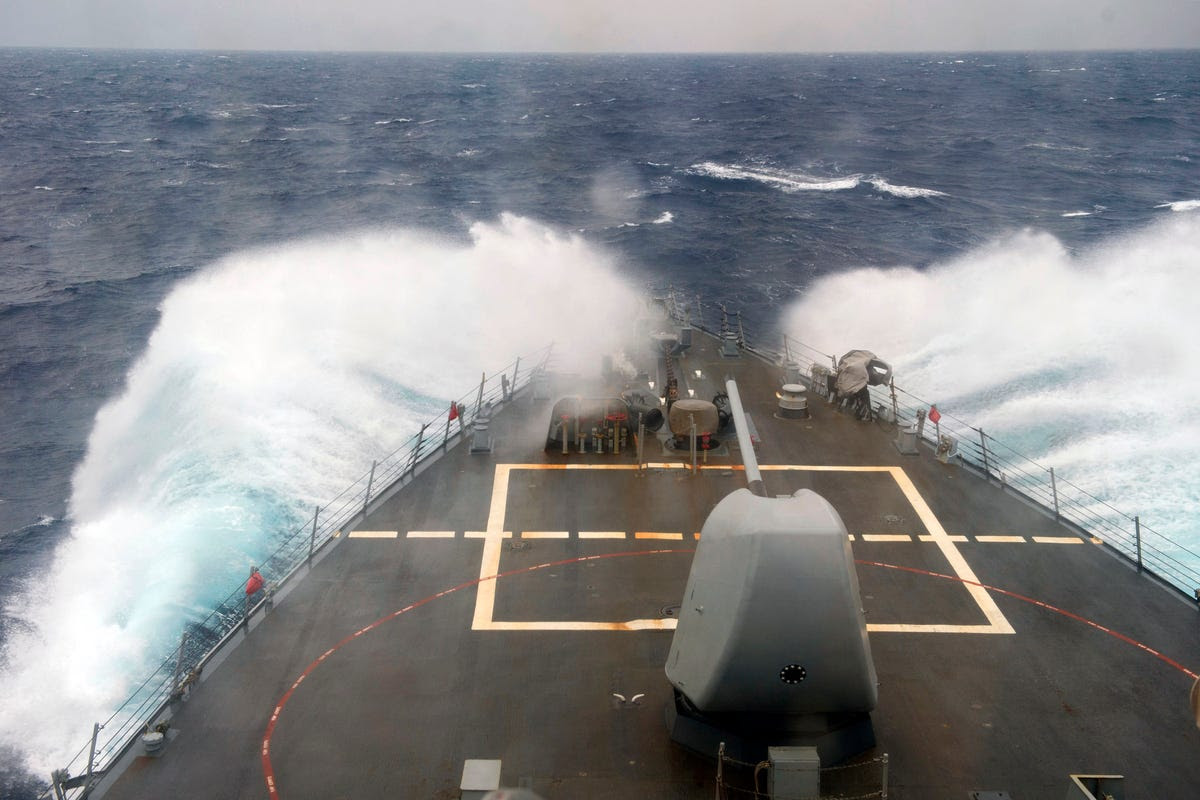 But carriers don't sail alone either. Here a guided missile destroyer knocks through some rough seas accompanying the Vinson.