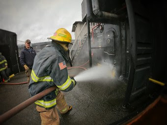 Person in firefighting gear extinguishing a fire