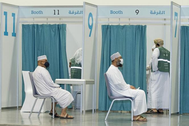 Des hommes attendent de recevoir une dose du vaccin contre le Covid-19, à Mascate, la capitale d’Oman, le 23 juin 2021.