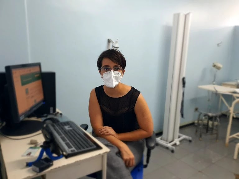 A médica Helena Paro sentada ao computador em seu consultório